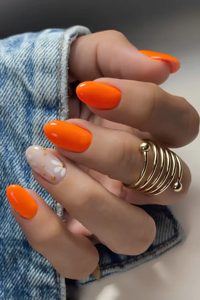 Bright orange mani with accent flowers