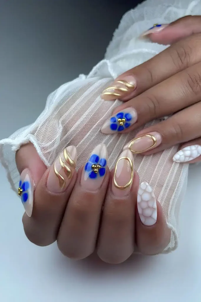 Neutral Nails With White Animal Print Blue Blooming Gel Florals And Gold Chrome Accents