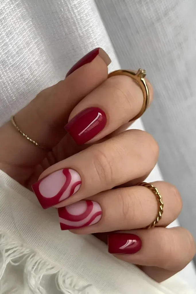 Cherry Red Nails With Abstract Swirls for a Modern Artistic Style