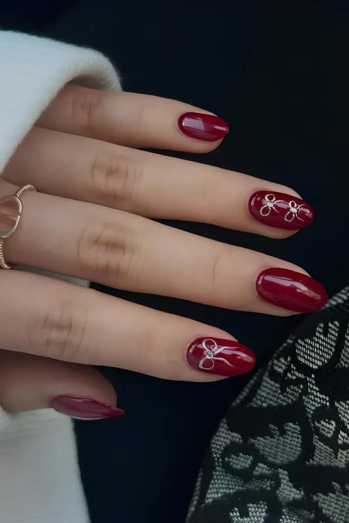Garnet Red Nails With Bow Accents for a Glam Look