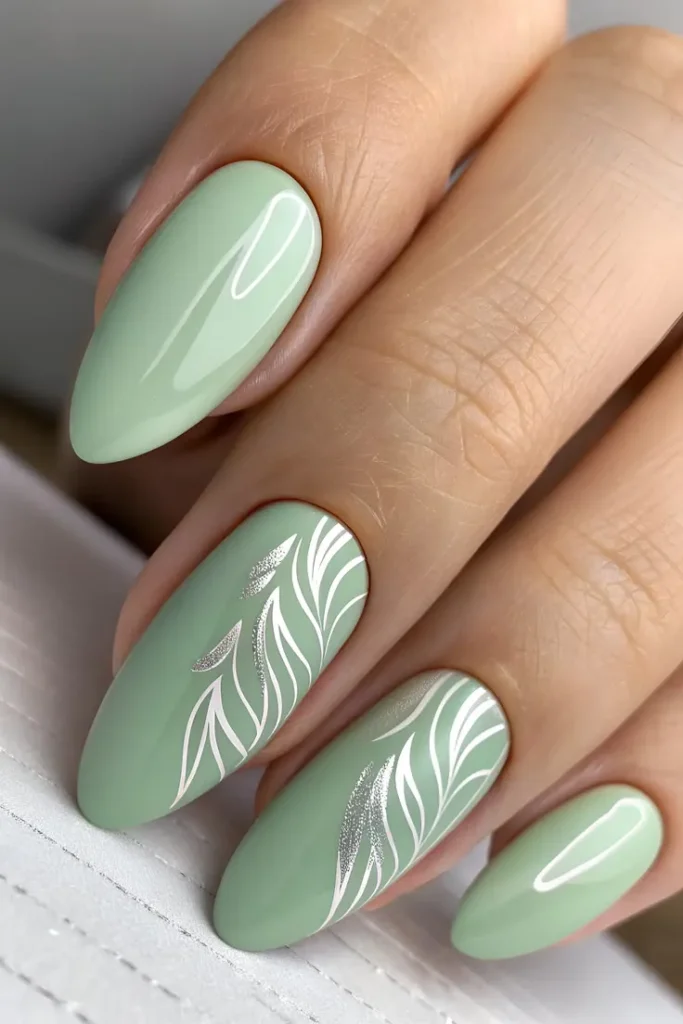 Sage Green Botanical Nails With an Elegant Almond Design and White Leaf Art