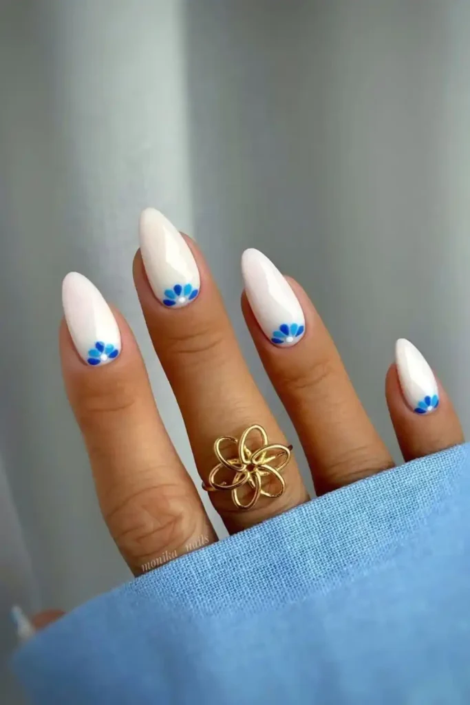White Nails With Blue Half Moon Flowers That Look Fresh and Feminine