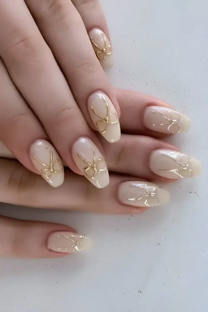 White Nails With Gold Chrome Bows for a Glamorous Finish